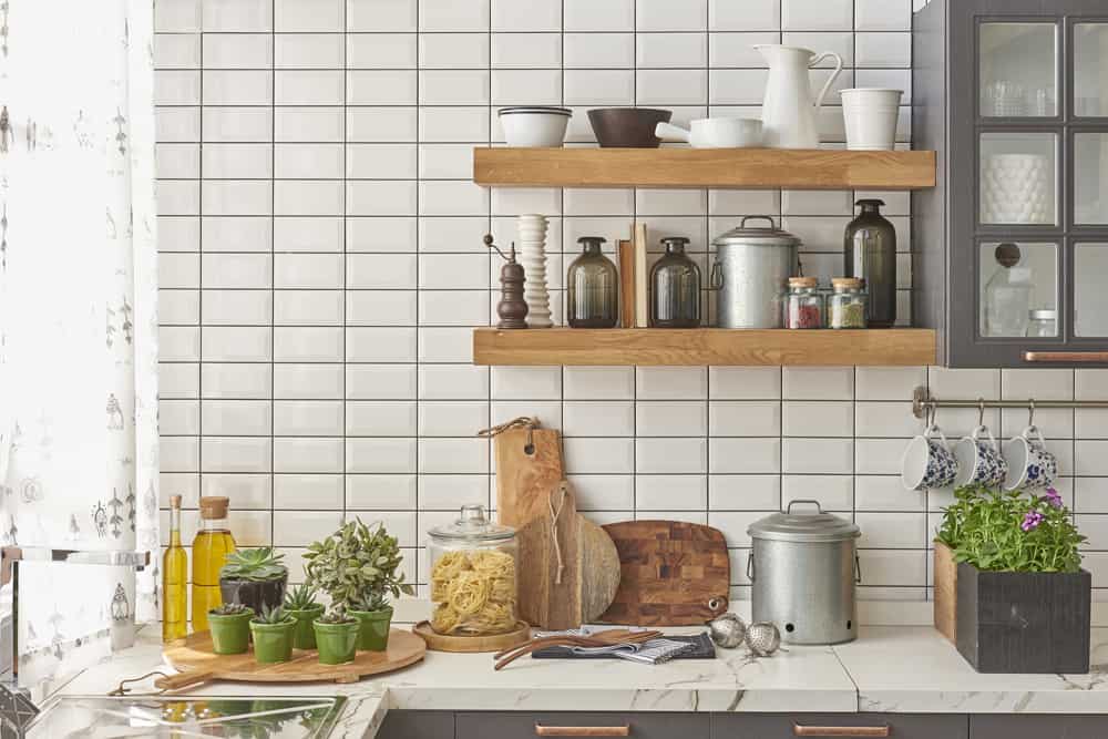 Kitchen with eco-friendly bamboo cutting boards and shelves with greenery and compost bin