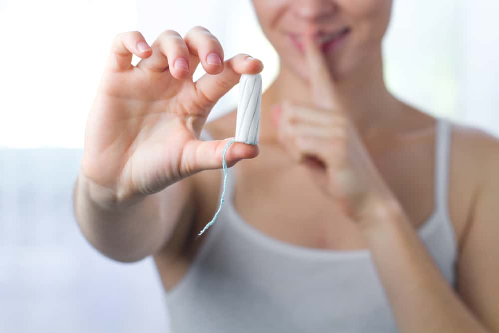 Attractive young woman holding a tampon.