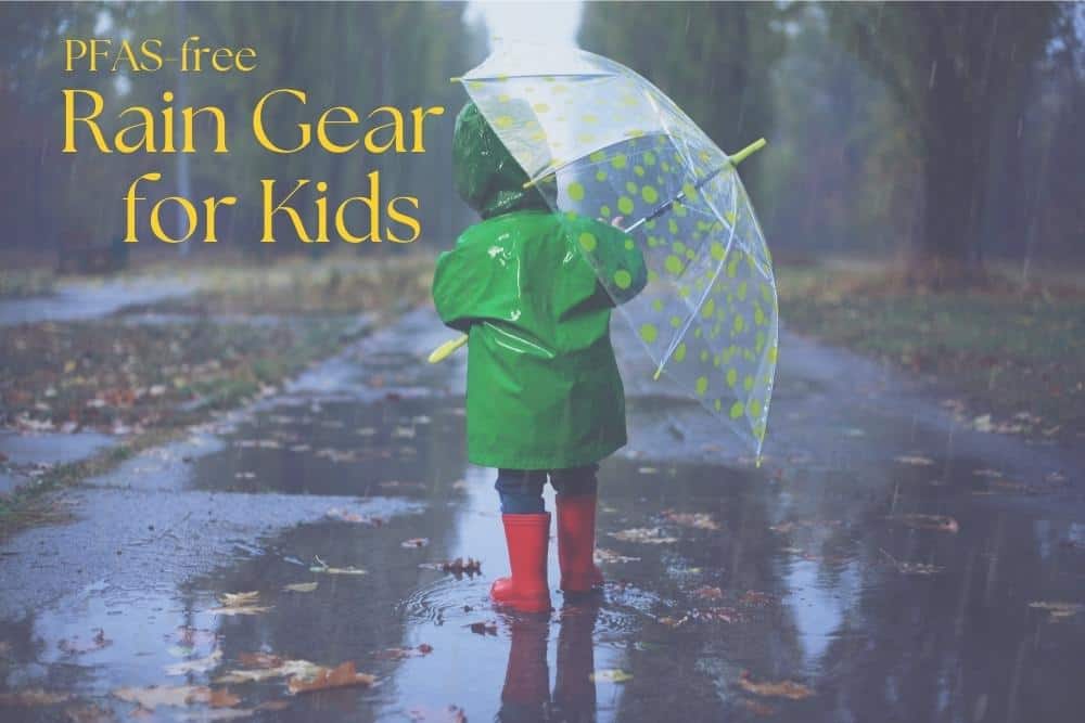 Boy with umbrella and rain boots in puddle