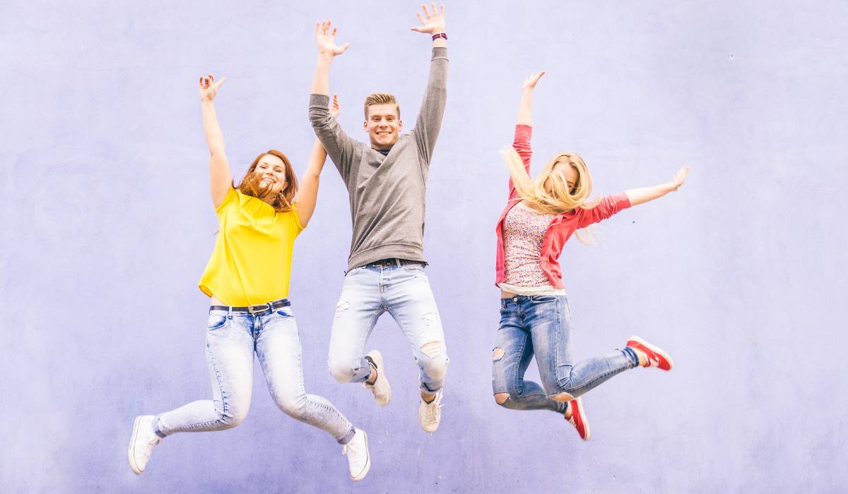 3 teenagers jumping with purple background