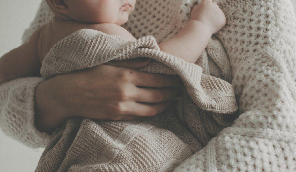 mother holding baby in blanket