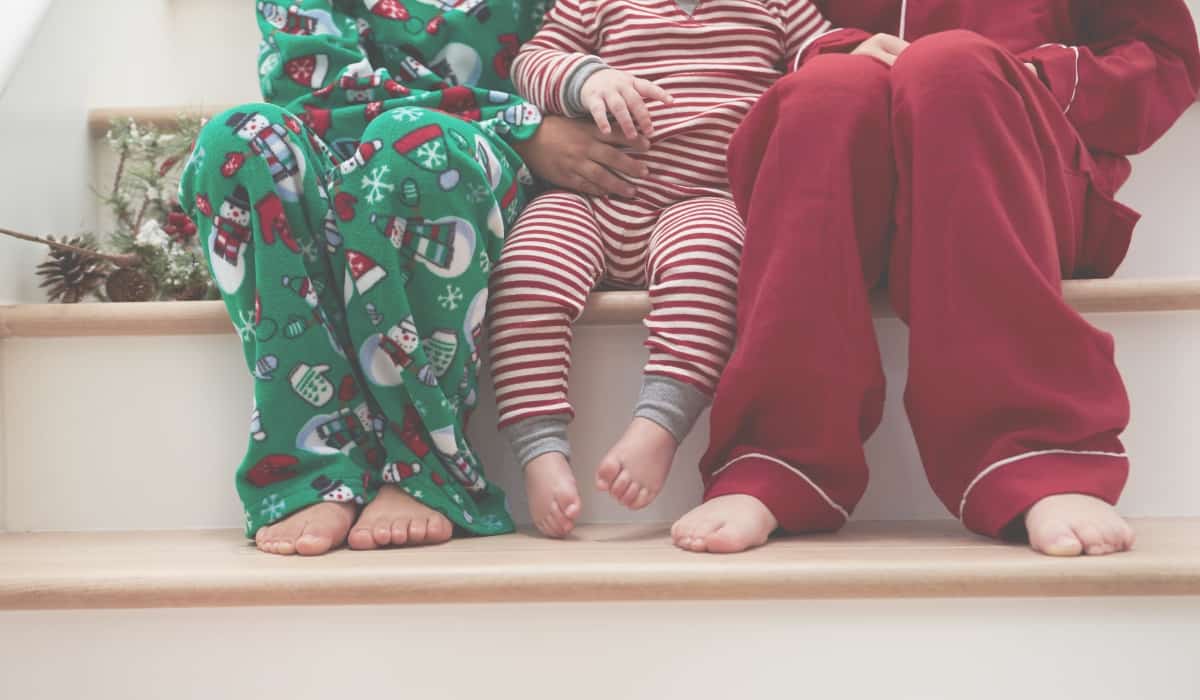 kids in holiday pajamas sitting on stairs