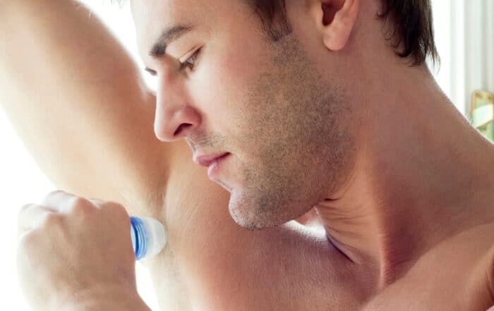man applying deodorant