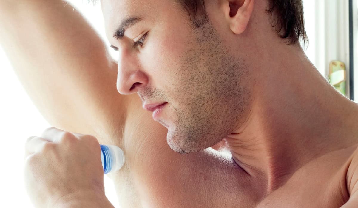 man applying deodorant