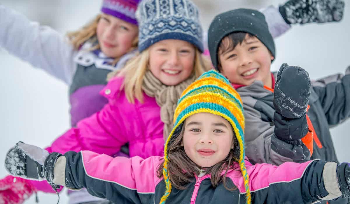 kids with winter clothing on in snow